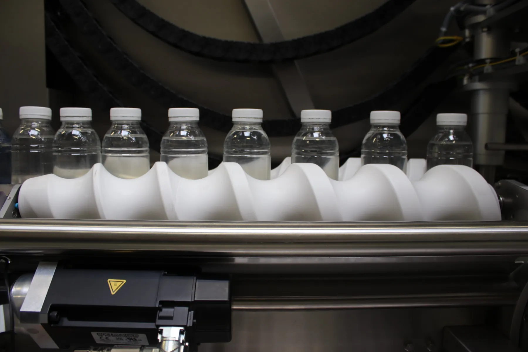 Straight-on close-up of timing screw paced bottles